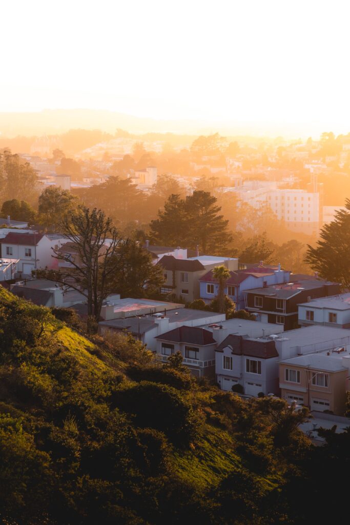 A beautiful view of hillside residential homes bathed in golden sunset light.